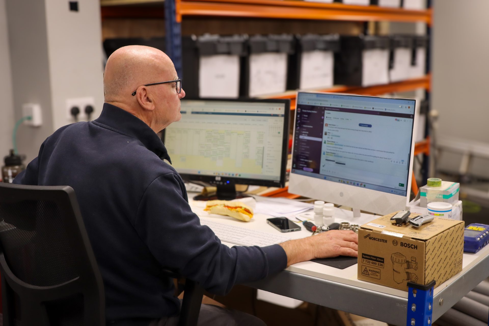 An employee working in a stockroom at their computer