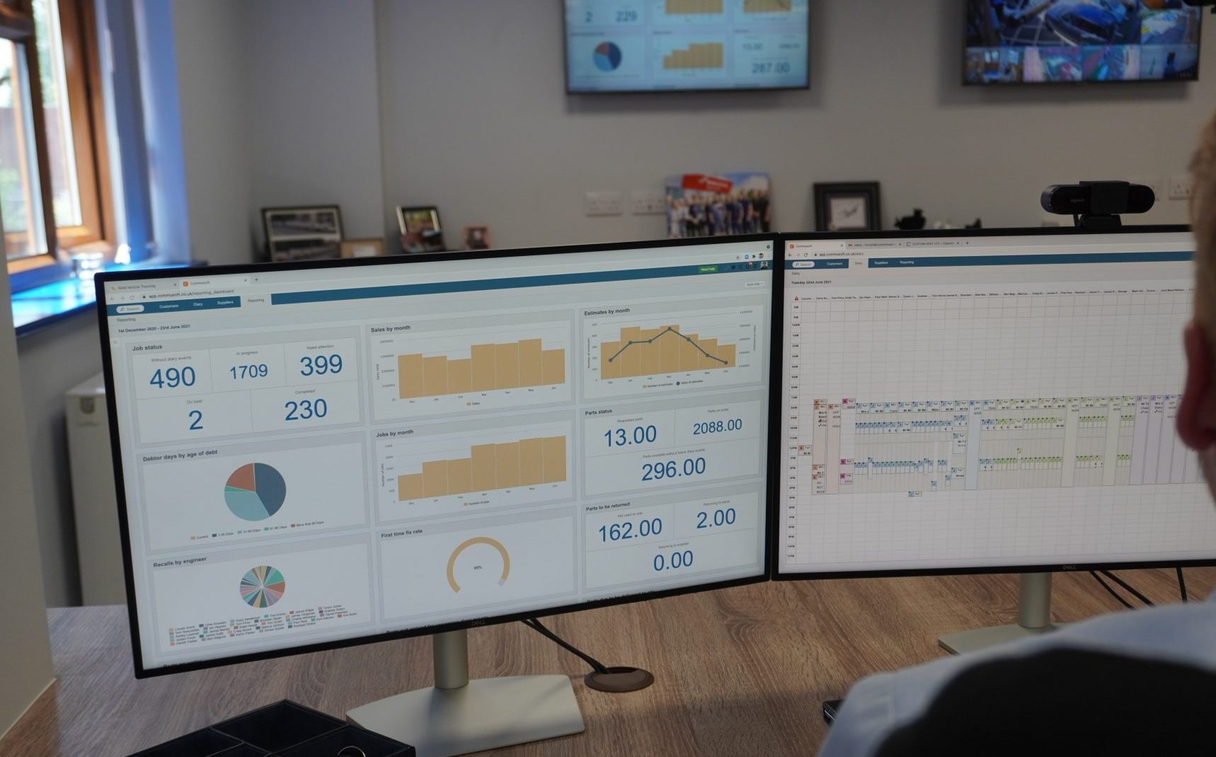 Office staff looking at Commusoft's job reporting feature on desktop