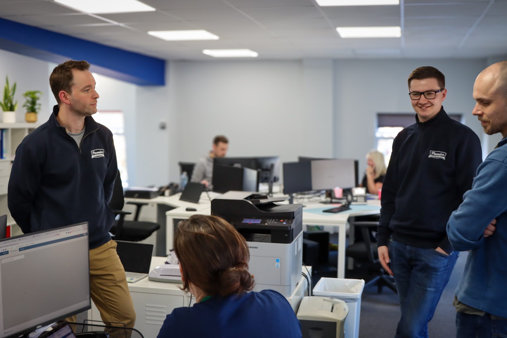 Premier Heating Solutions team members chatting in the office with Commusoft