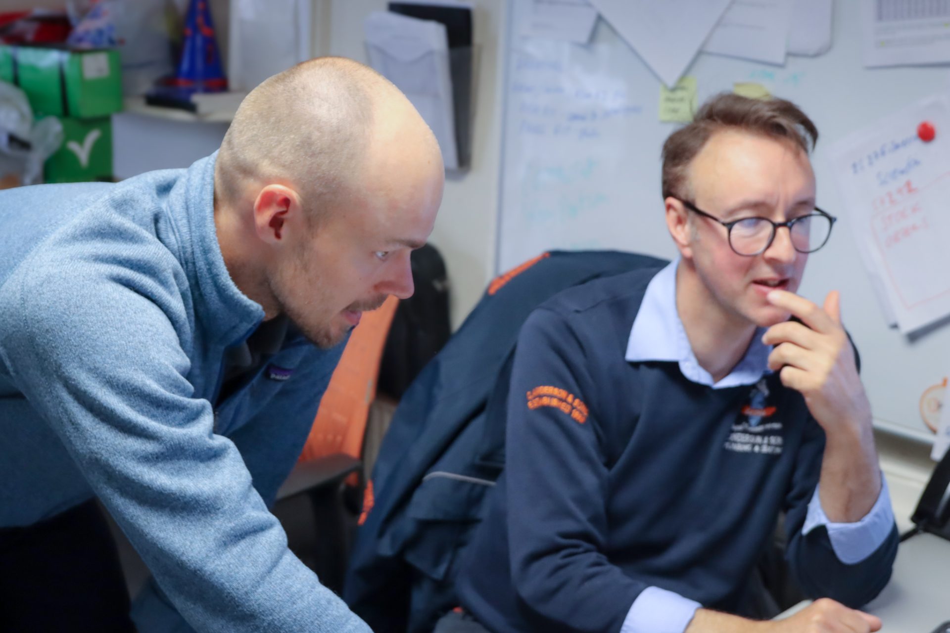 Commusoft team member chatting with C. Anderson & Sons employee at their desk