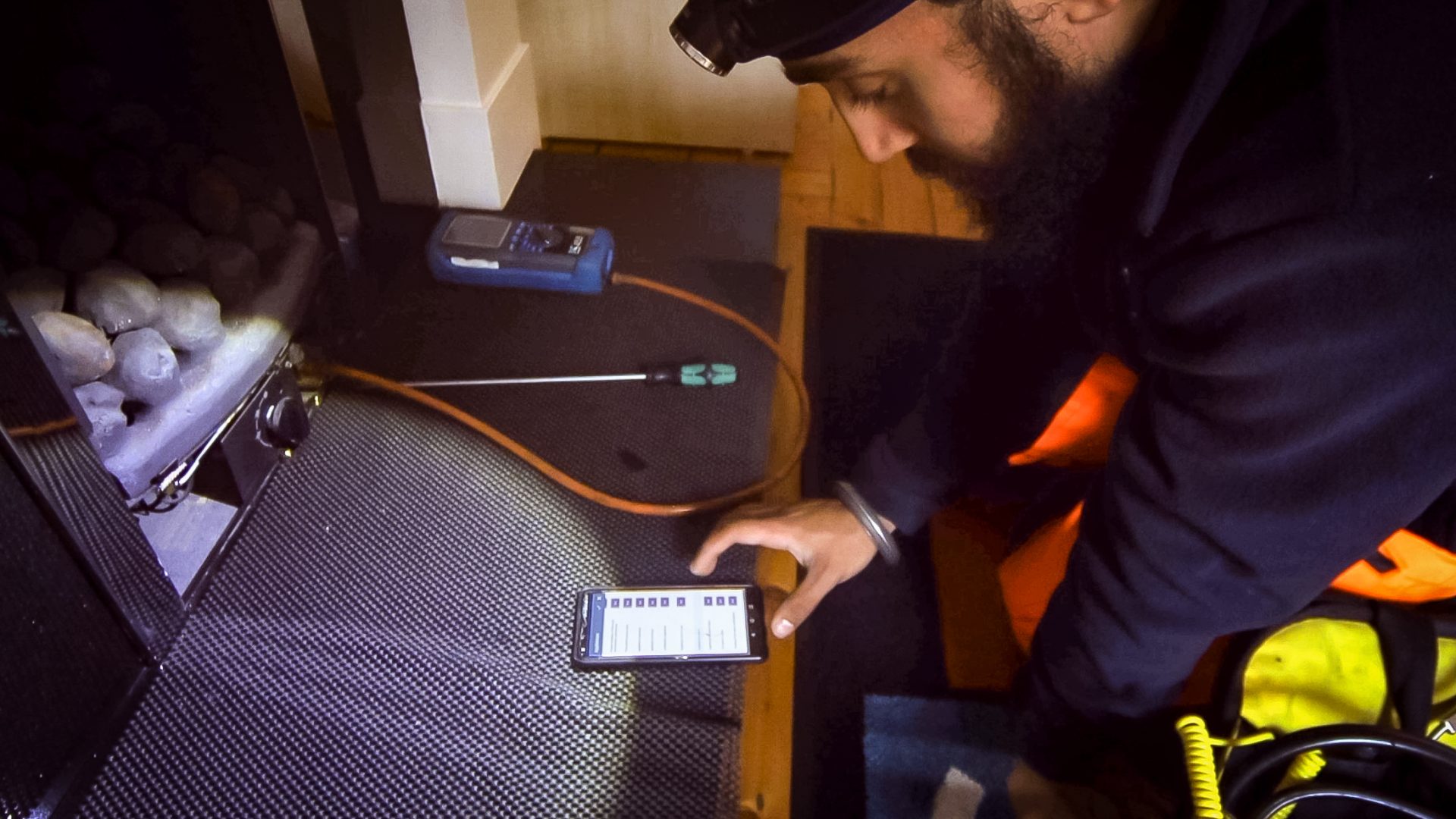 Engineer at work and completing a job on Commusoft's mobile app