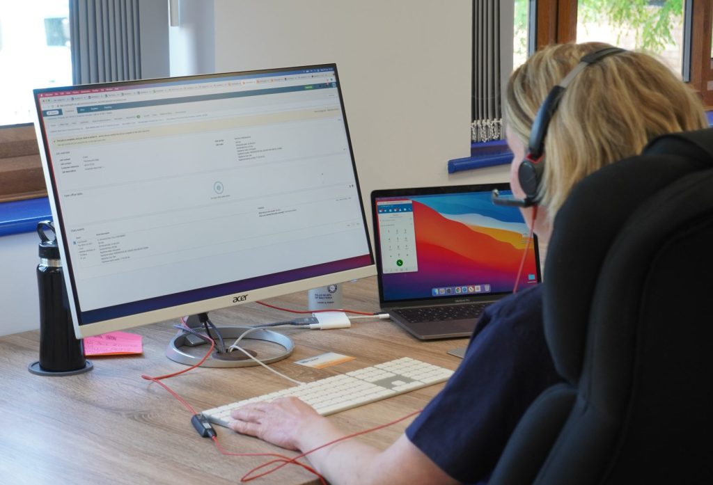 Employee with a headset working on Commusoft