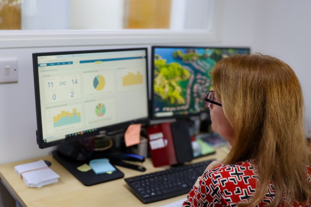 Employee looking at Commusoft's reporting feature while sat at their desk
