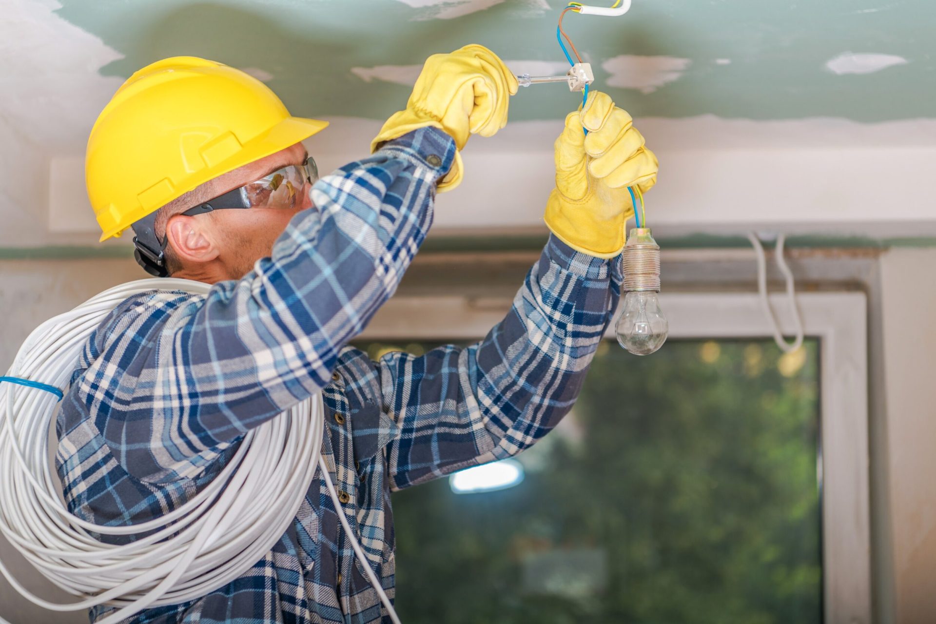Engineer holding a coil of wires and fixing a light