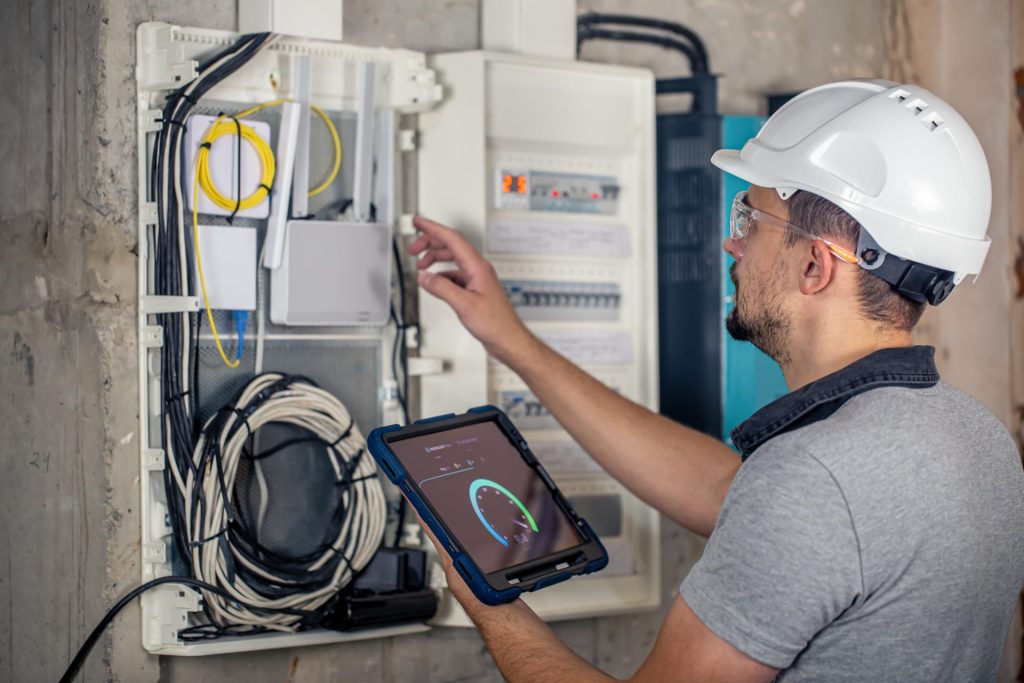 Engineer taking readings on their tablet while on a job