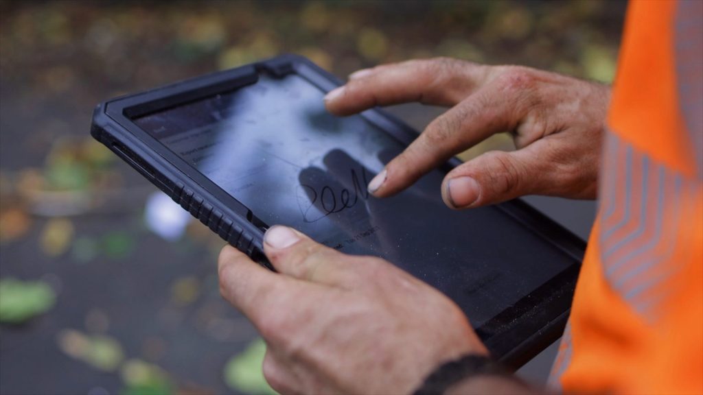 Engineer writing signature on the Commusoft job report on their iPad