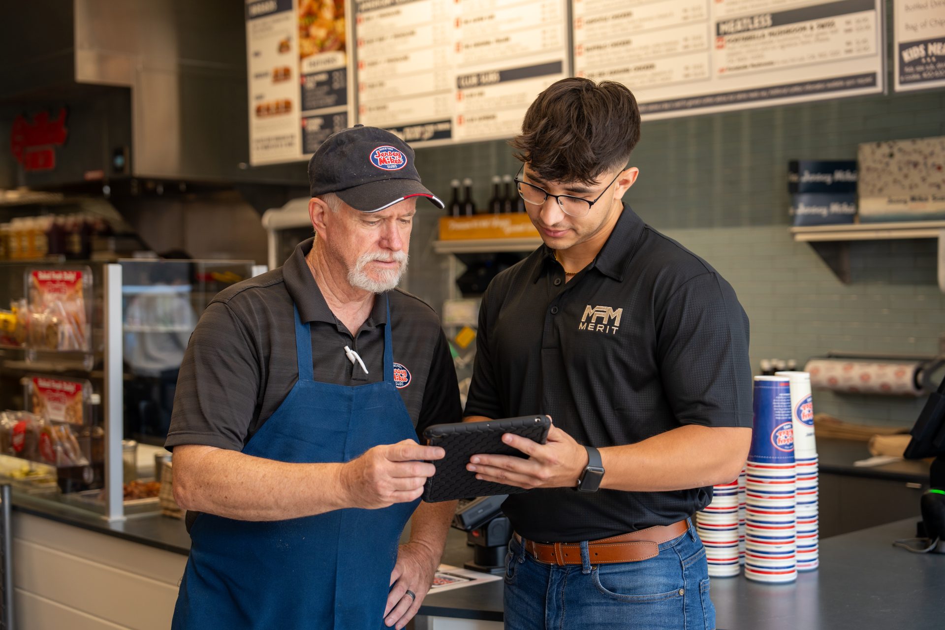 Merit Facility Management team member showing client information on an iPad
