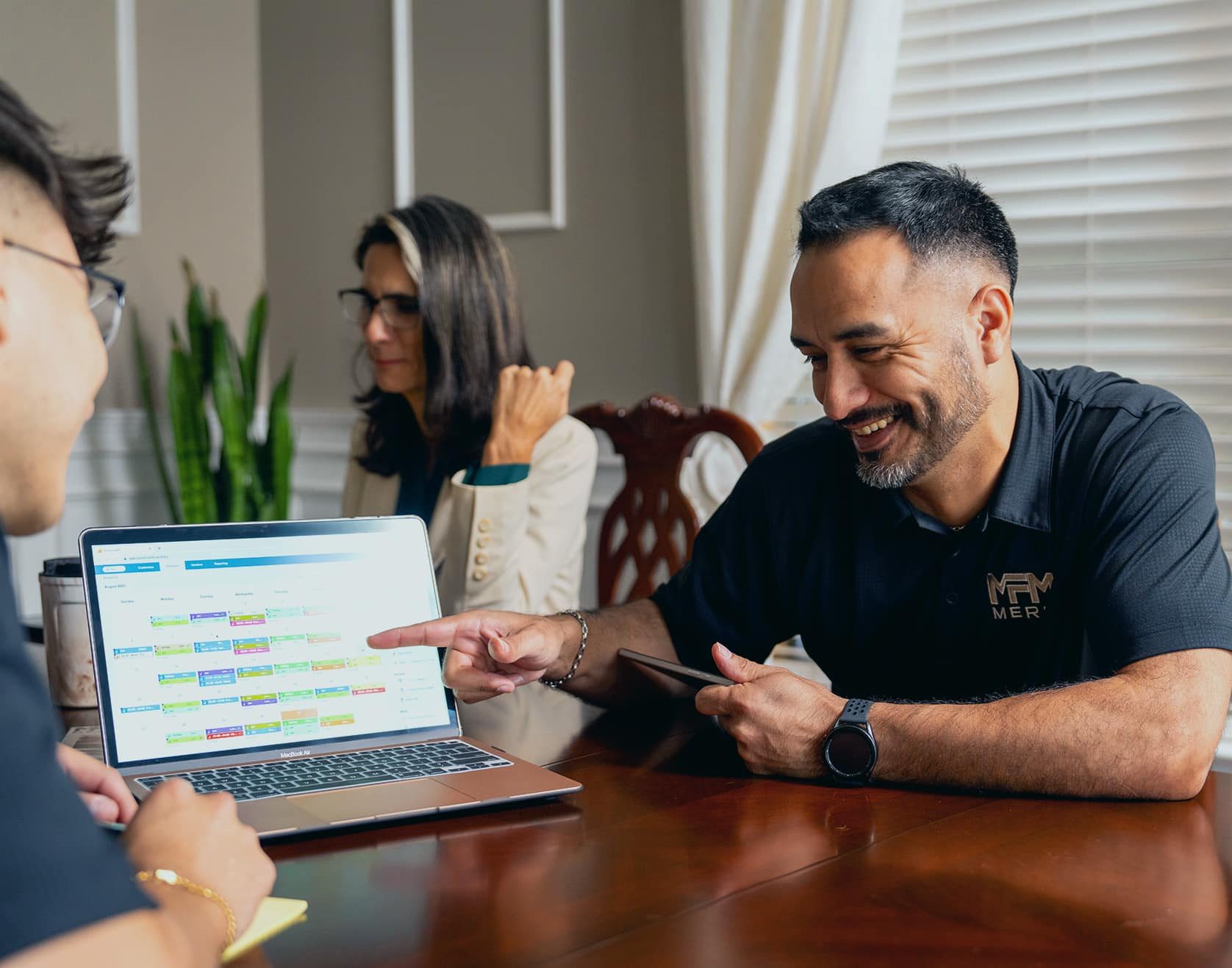 Merit Facility Management team members laughing and looking at a laptop
