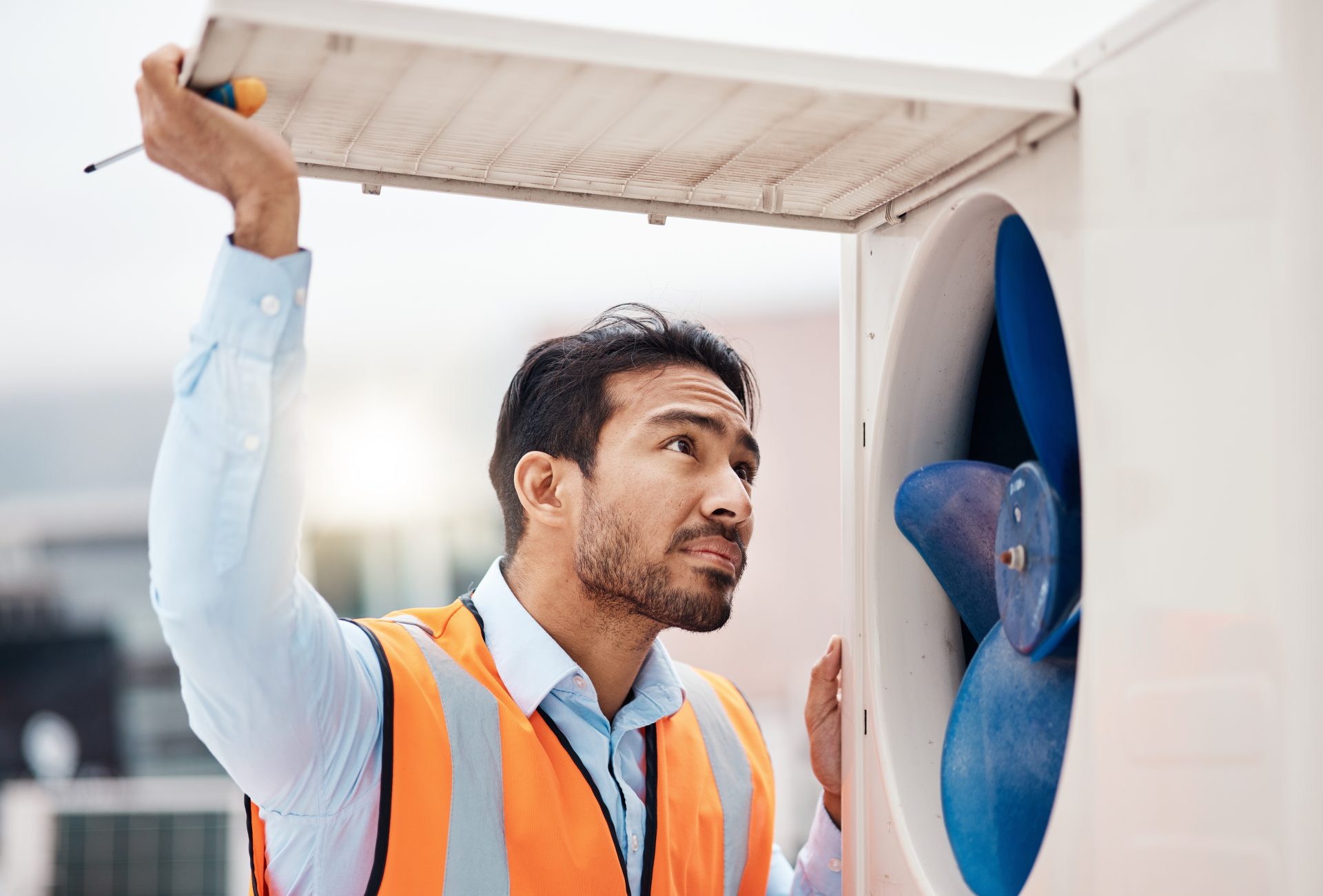 Worker inspecting a HVAC system outside