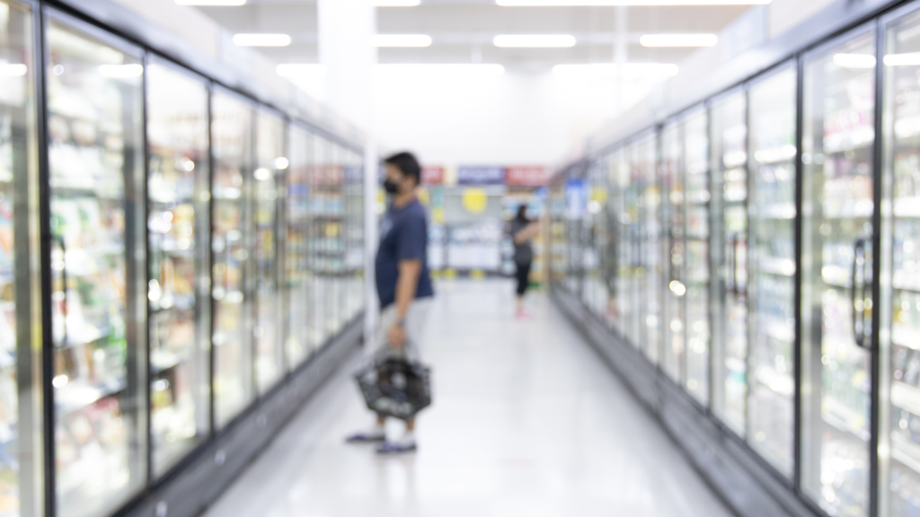 Two people shopping in fridge aisle of the supermarket
