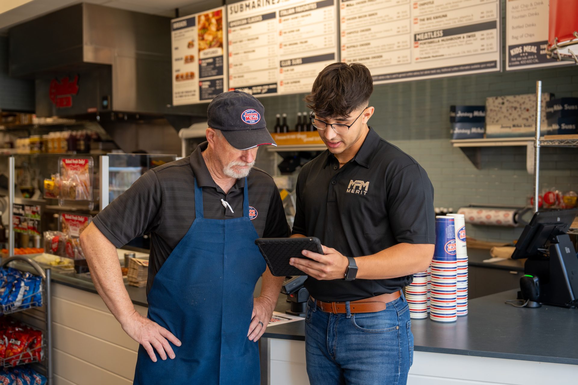 Merit Facility Management team member showing information on an iPad to a client